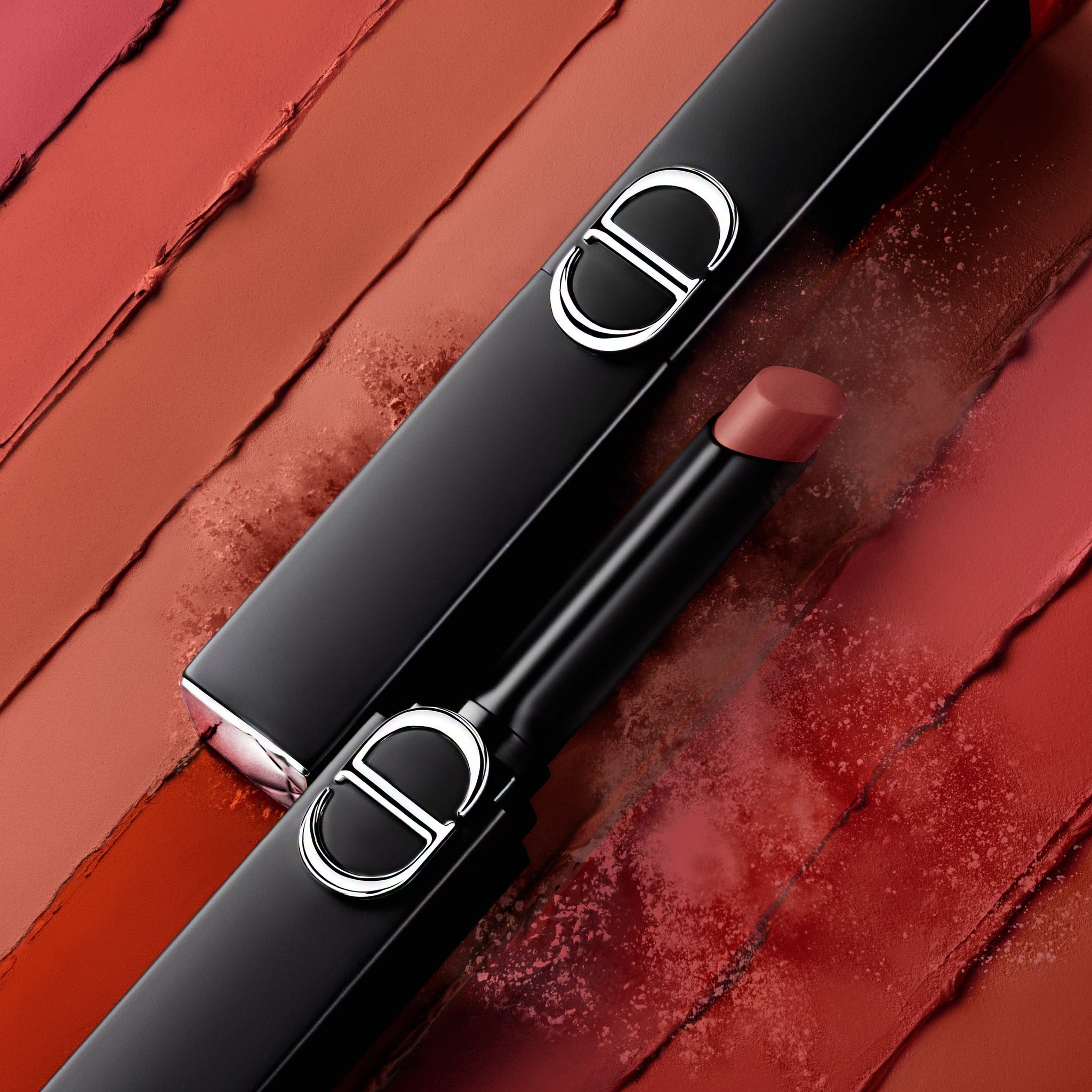 Dior lipstick swatches on red orange background