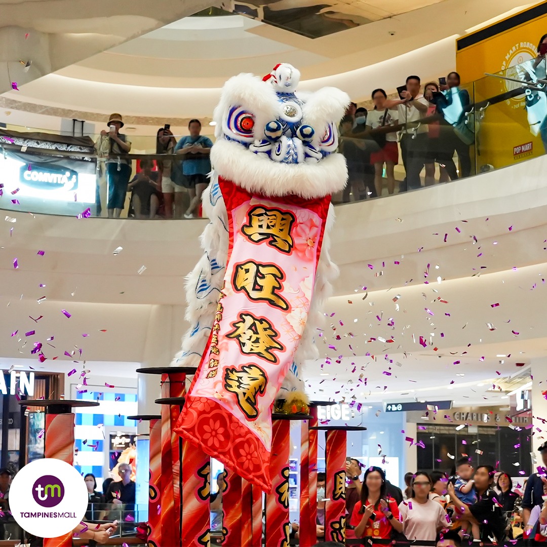 Lion dance performers executing impressive high-pole stunts