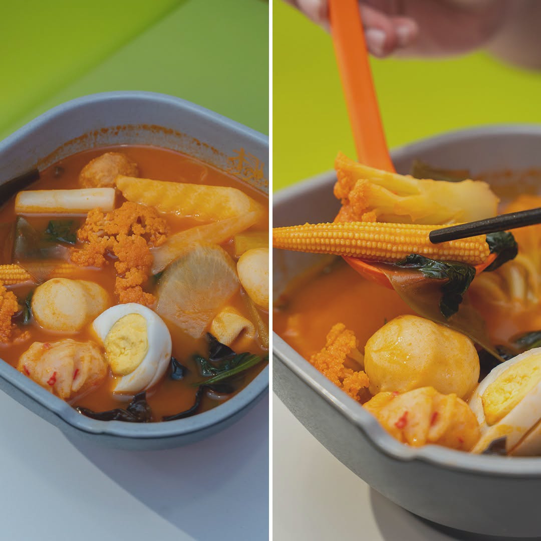 Malatang bowl with spicy orange broth, rice cakes and fish cake